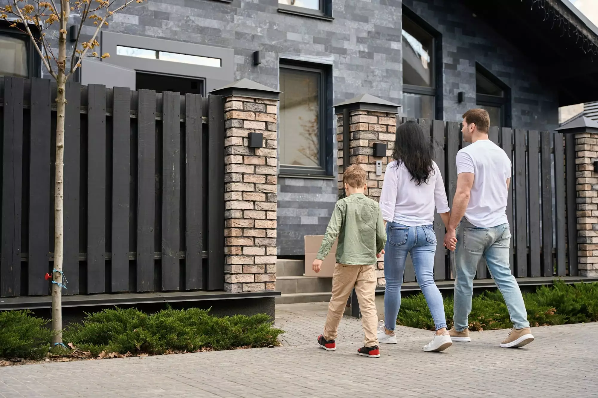 Family enters the house through the gate